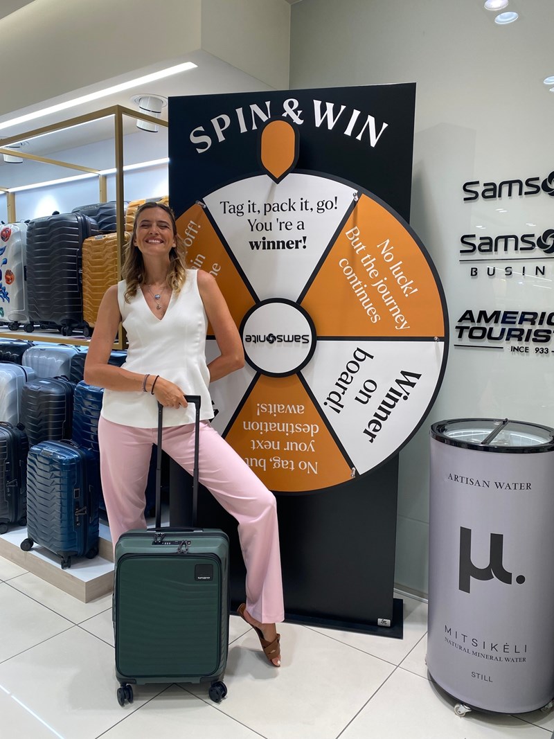 Μια γυναίκα ποζάρει στη γωνία της Samsonite στο Attica City Link