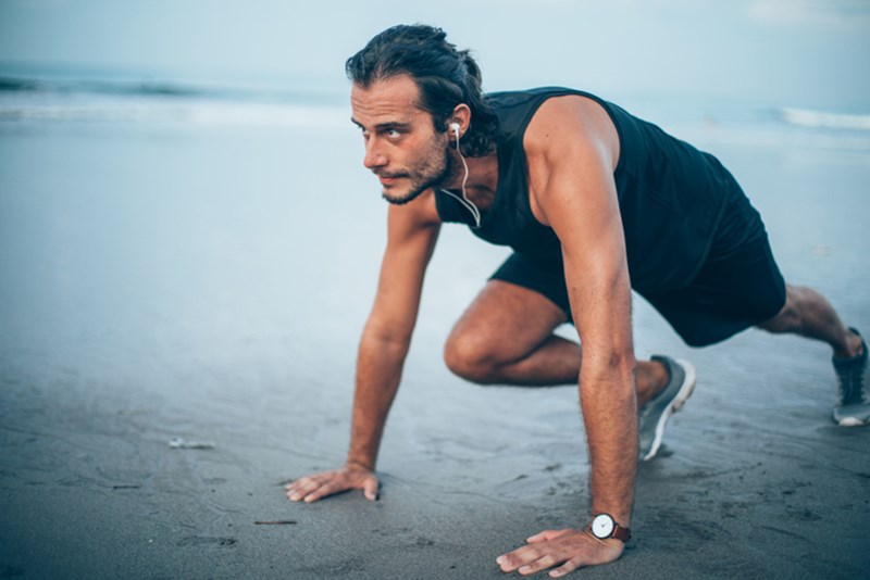 MAN DOING FITNESS WORKOUT AT THE BEACH