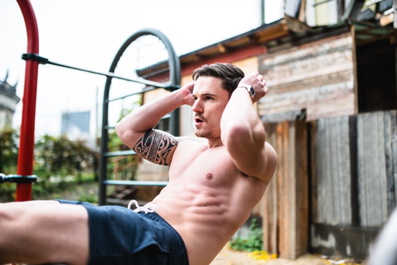 MAN DOING CRUNCHES OUTDOORS