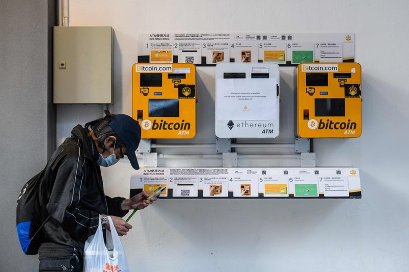 A MAN PASSES BY ATM MACHINES FOR DIGITAL CURRENCY HONG KONG