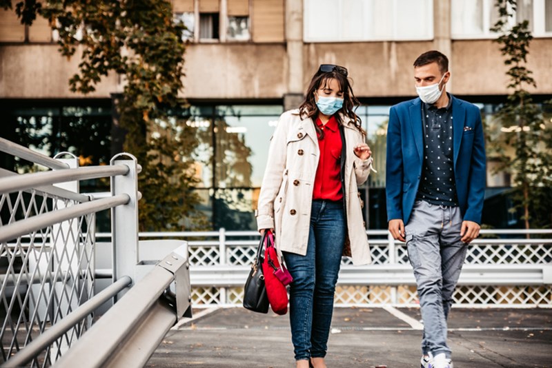 PEOPLE WITH PROTECTIVE FACE MASKS WALKING SIDE BY SIDE