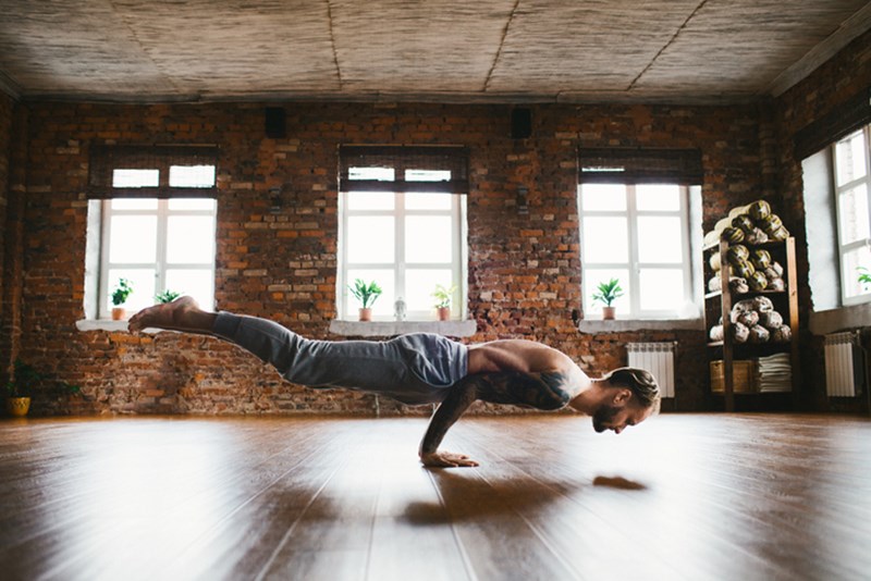 MAN DOING YOGA IN STUDIO