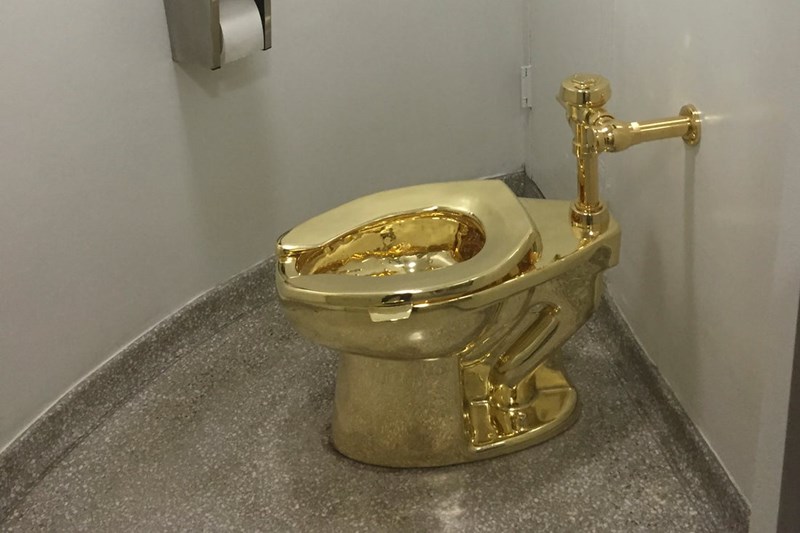 A FULLU FUNCTIONING SOLID GOLD TOILET MADE BY ITALIAN ARTIST MAURIZIO CATTELAN