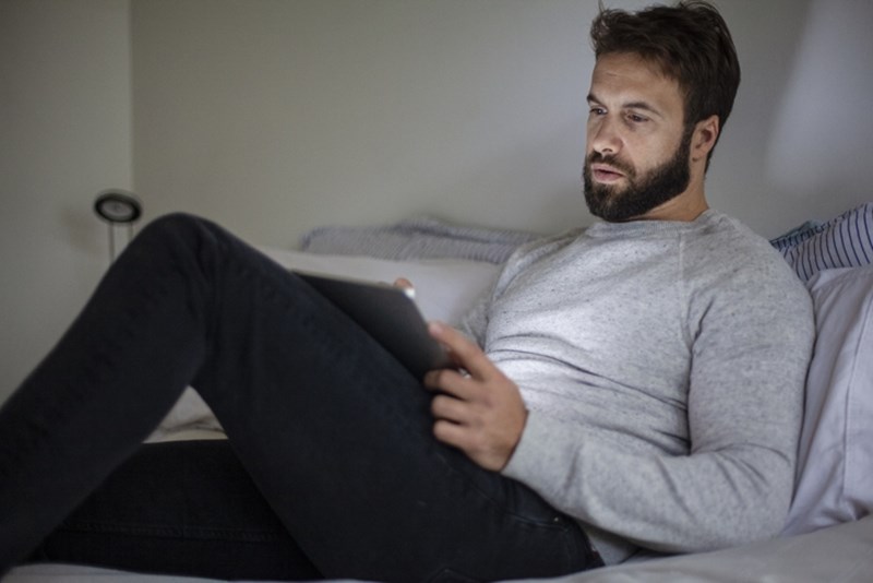 MAN WATCHING SOMETHING ON TABLET