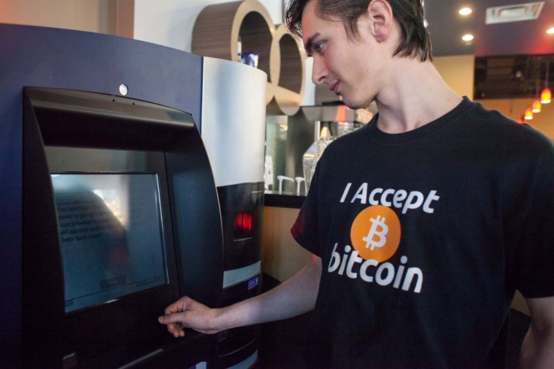 MAN IN FRONT OF A BITCOIN ATM