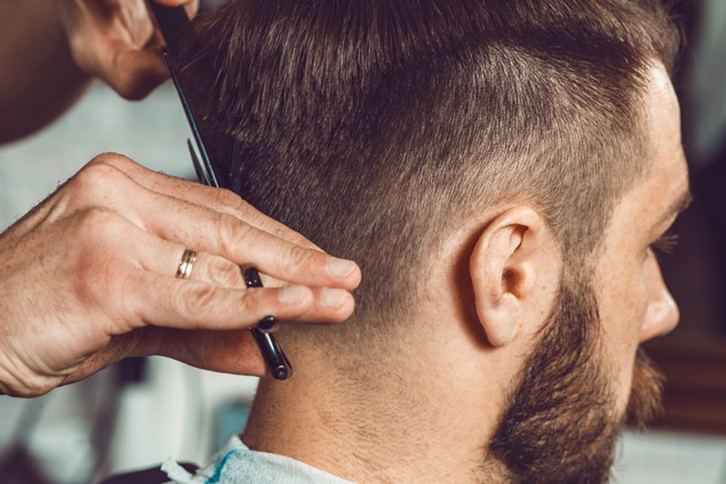MAN HAVING HIS HAIR CUT