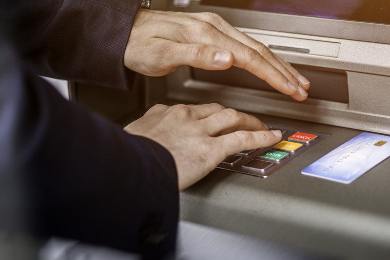 άντρας καλύπτει το pin σε atm