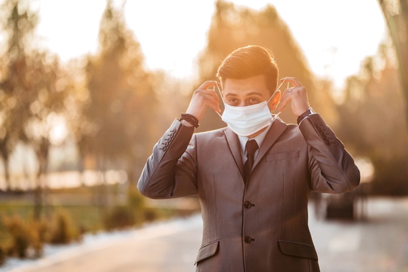 BUSINESSMAN PUTTING FACE MASK