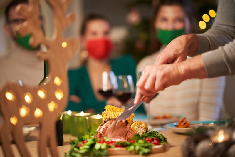PEOPLE WITH FACE MASKS AT CHRISTMAS TABLE