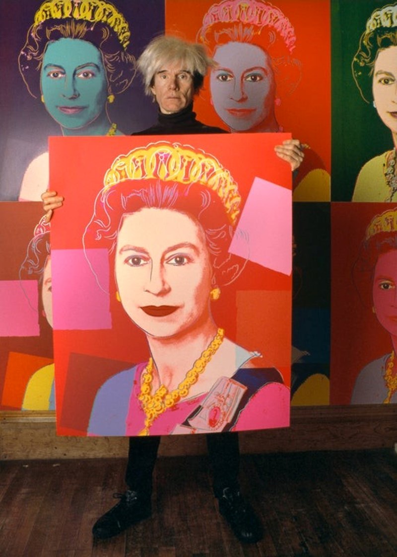 ANDY WARHOL HOLDING A PORTRAIT OF QUEEN ELIZABETH II