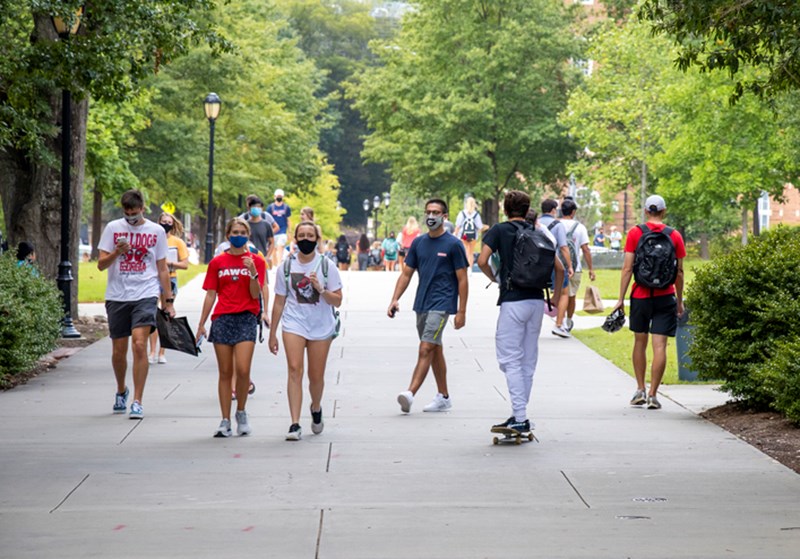 STUDENTS WEAR FACE COVERINGS WHILE WALKING ON CAMPUS