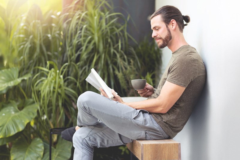 MAN RELAXING WHILE READING A BOOK