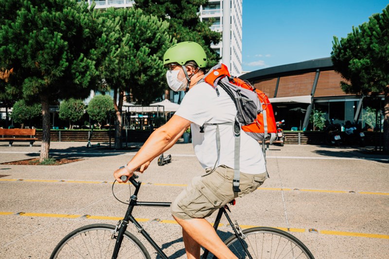MAN WITH PROTECTIVE MASK, RIDING A BICYCLE